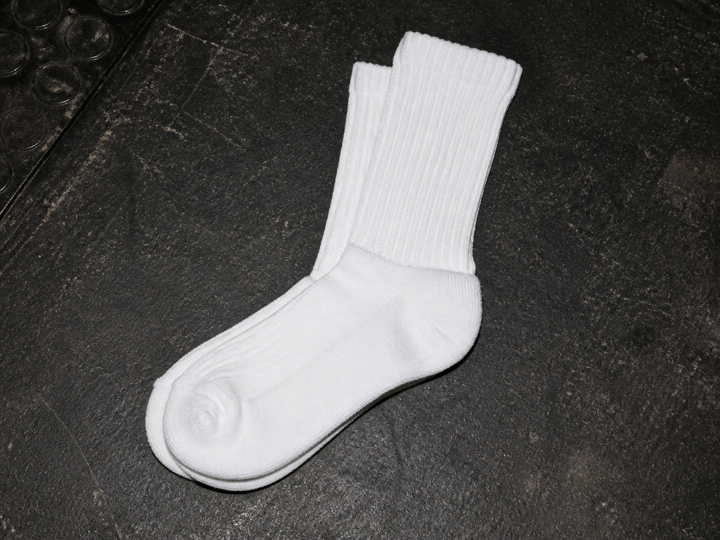 Ice-white Keep Rolling crew socks on a workshop floor